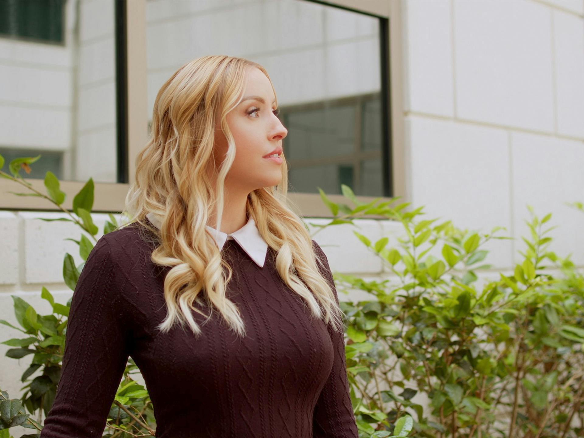Blonde woman wearing knitted sweater standing outside