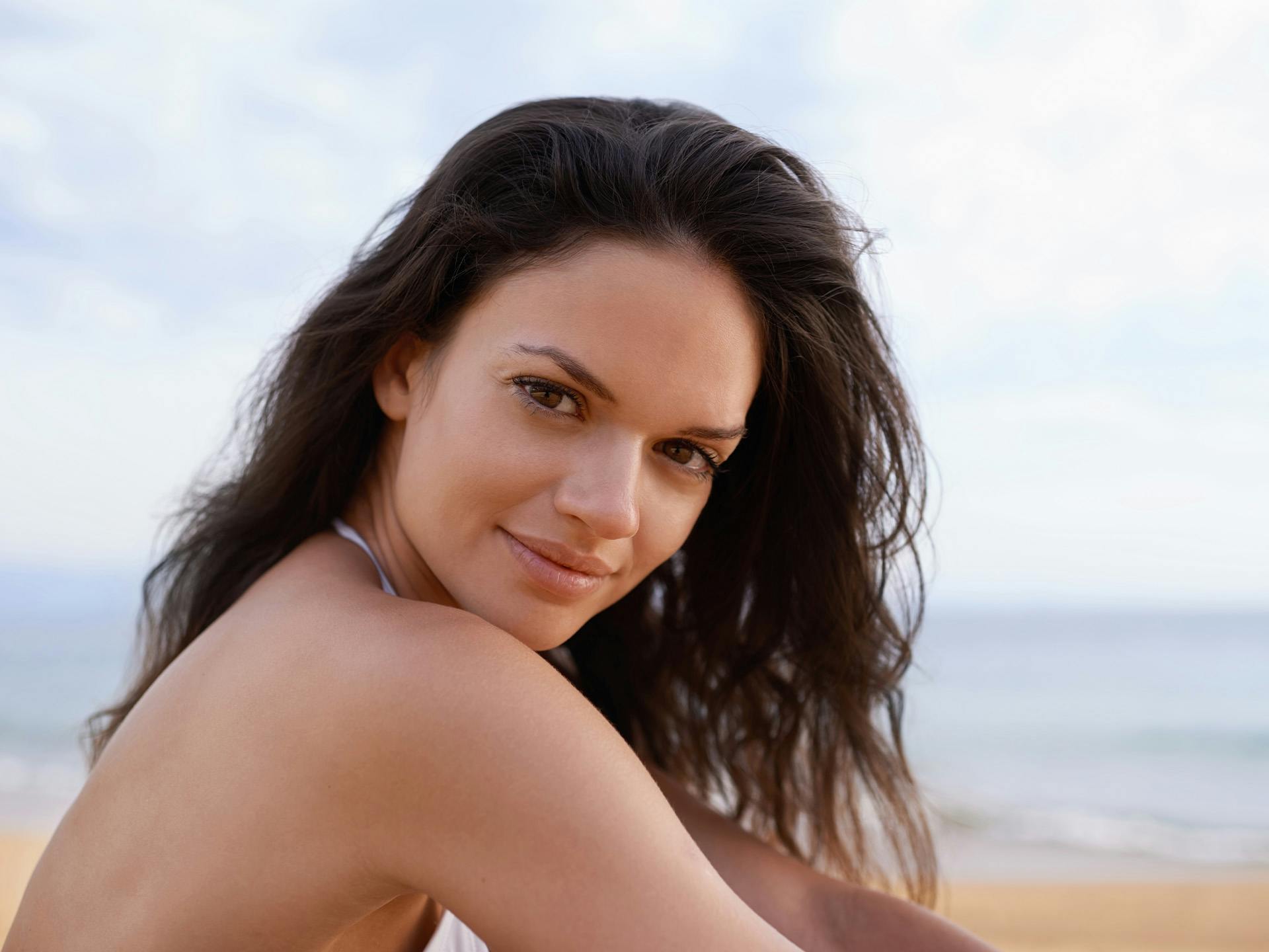 Woman with brown hair sitting at the beach