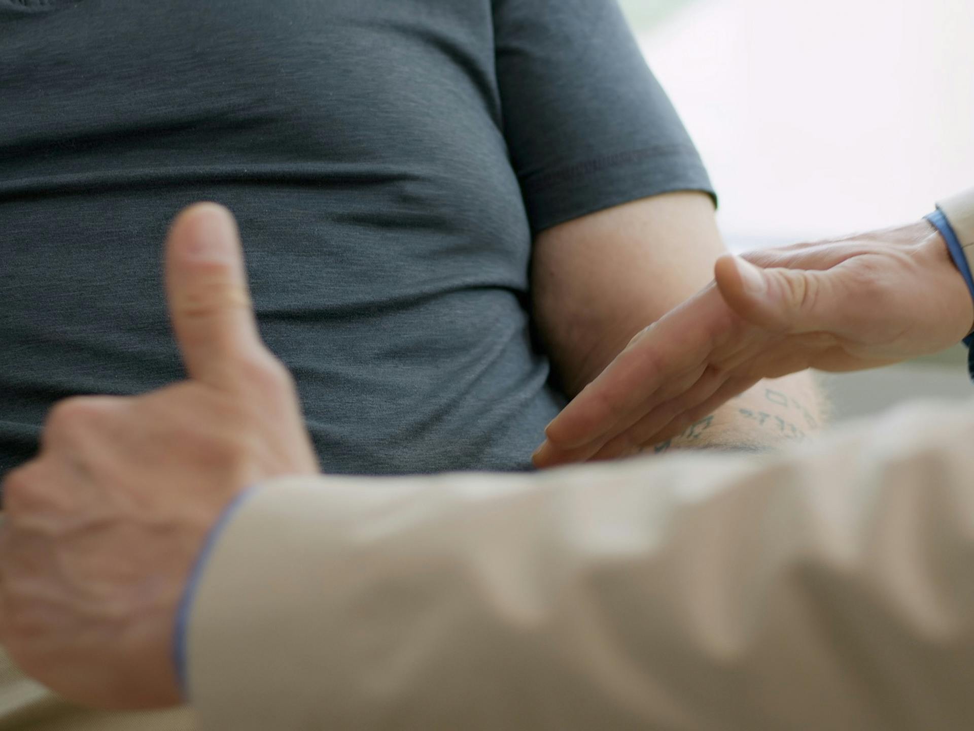 Man having his stomach checked by doctor during consultation