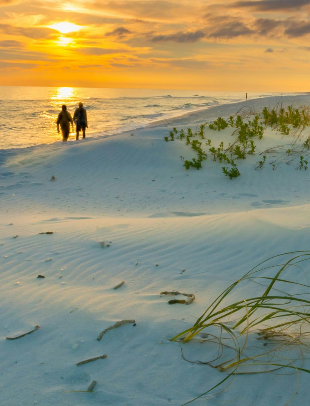 Two people walking on the beach
