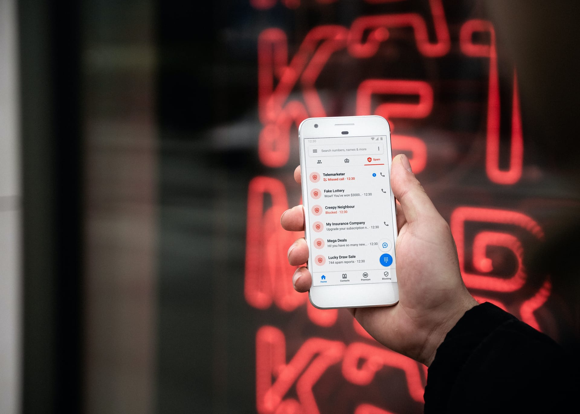 A male hand holds a smartphone to check the text messages in his inbox.