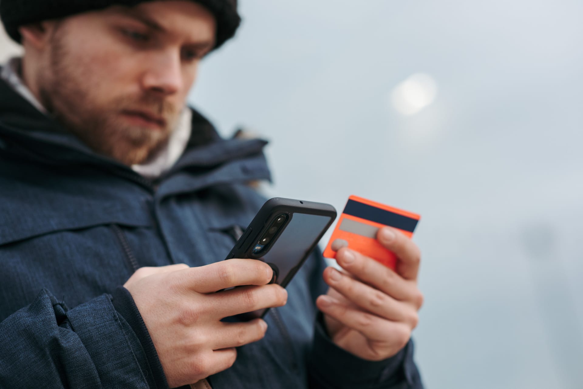 A young man enters his credit card data on a smartphone