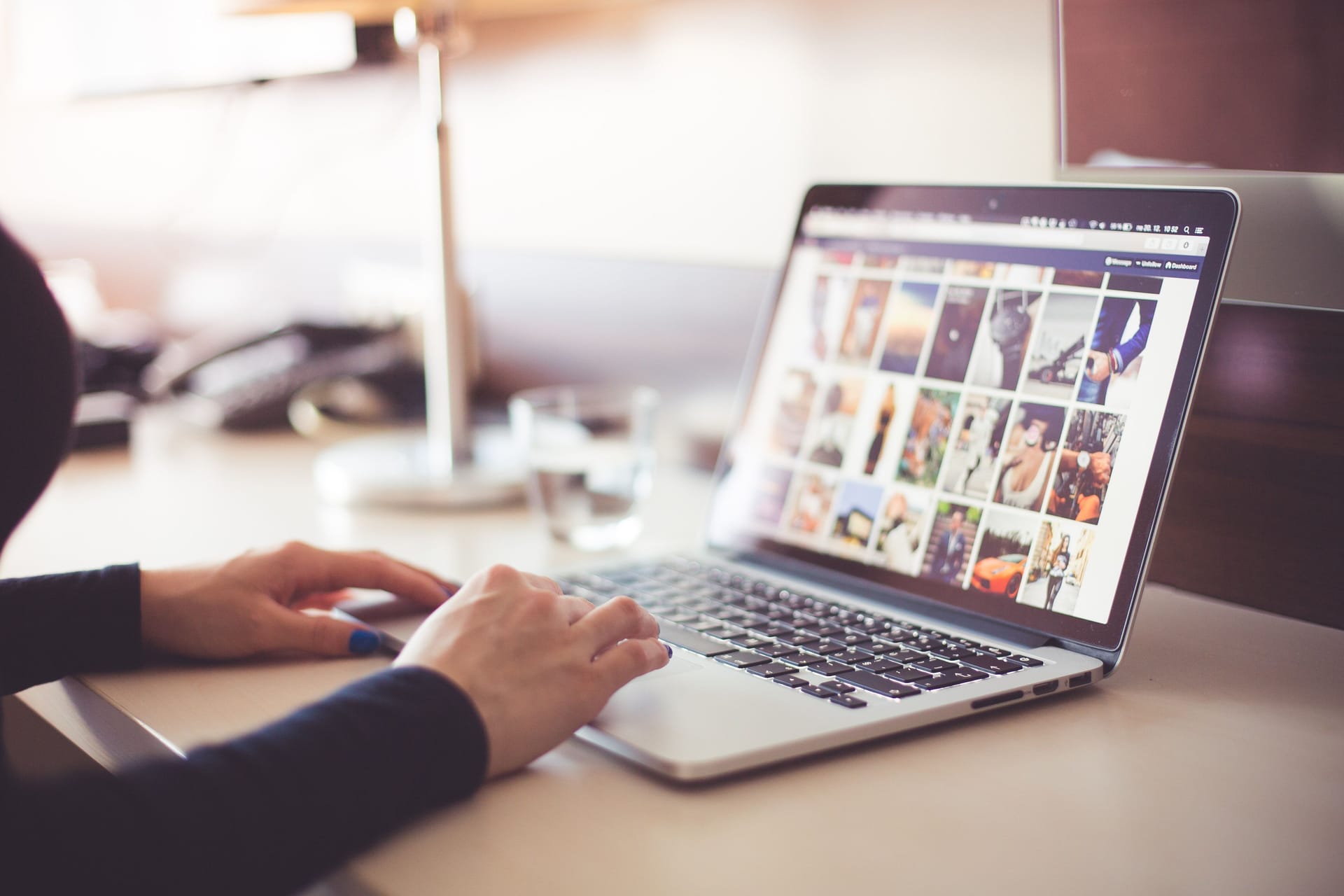 A woman looks at photos on a website on her laptop