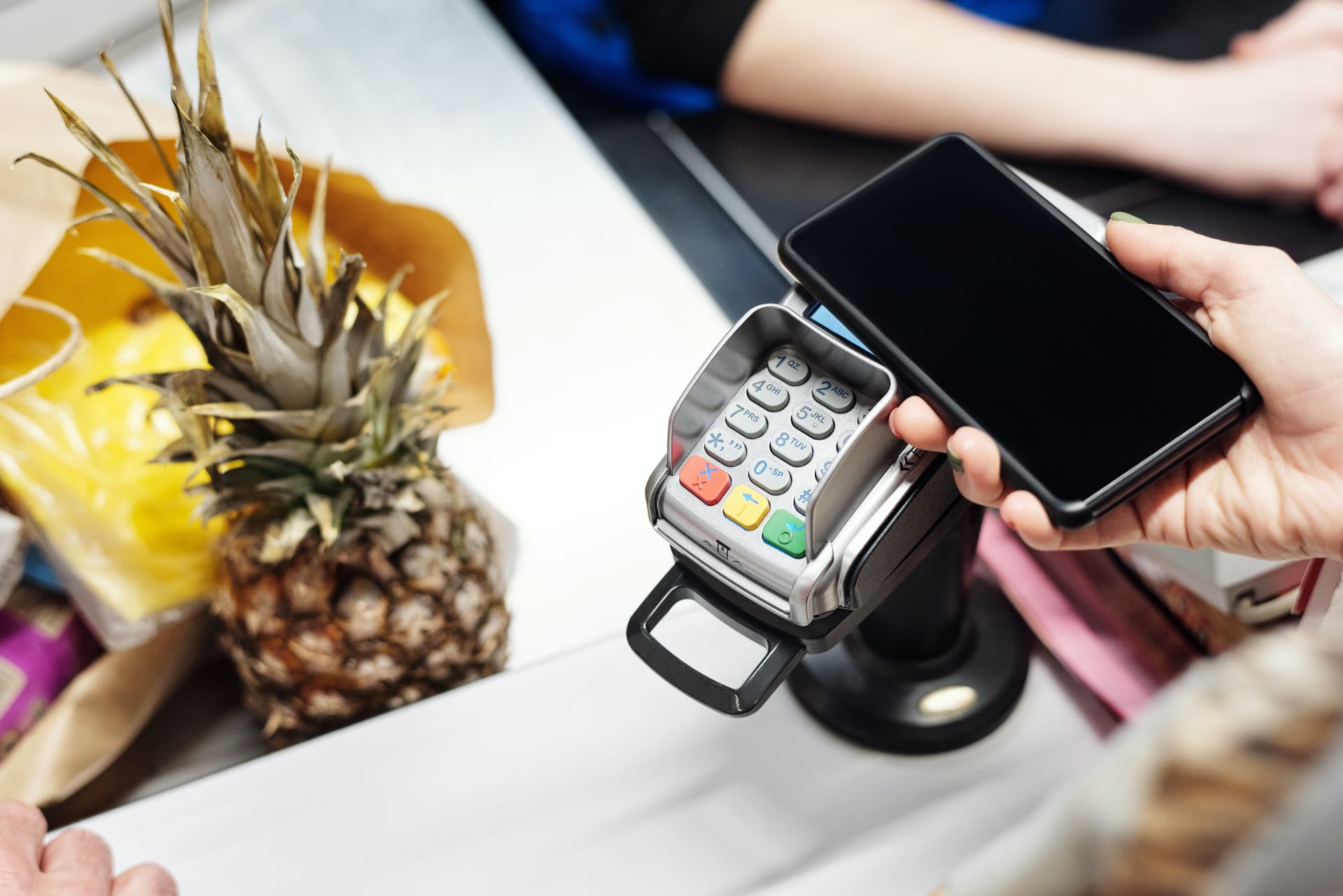 Someone who is paying for groceries at the supermarket using an electronic wallet.