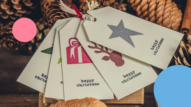 Five Christmas tags attached together with pinecones around