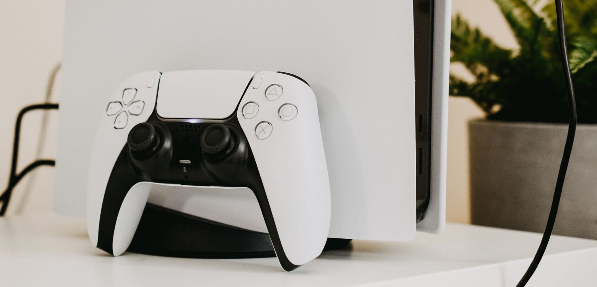 PlayStation 5 controller leaning against a PS5 console.