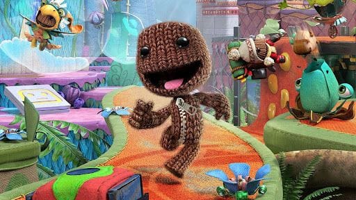 Capture d'écran de Sackboy : A Big Adventure. Le personnage principal court sur un parcours d'obstacles coloré.