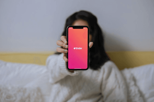 Person, die Handy mit Tinder-App hält.