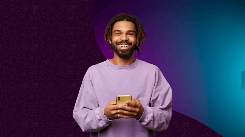 Man holding phone in front of a purple background.