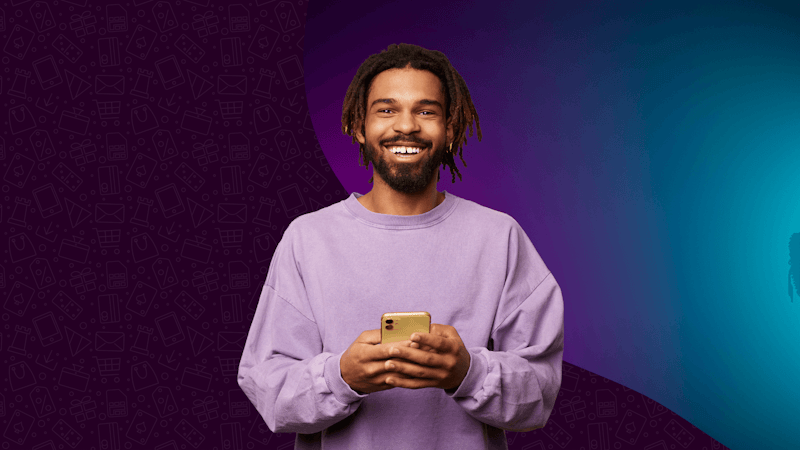 Eine Person hält ein Handy vor einem violetten Hintergrund.