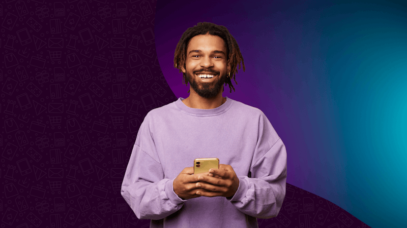Homme tenant un téléphone devant un fond violet.