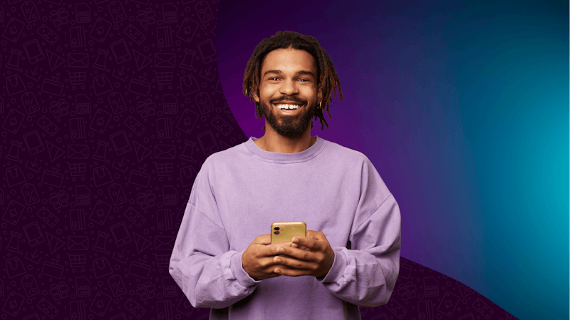 Homme tenant un téléphone devant un fond violet.