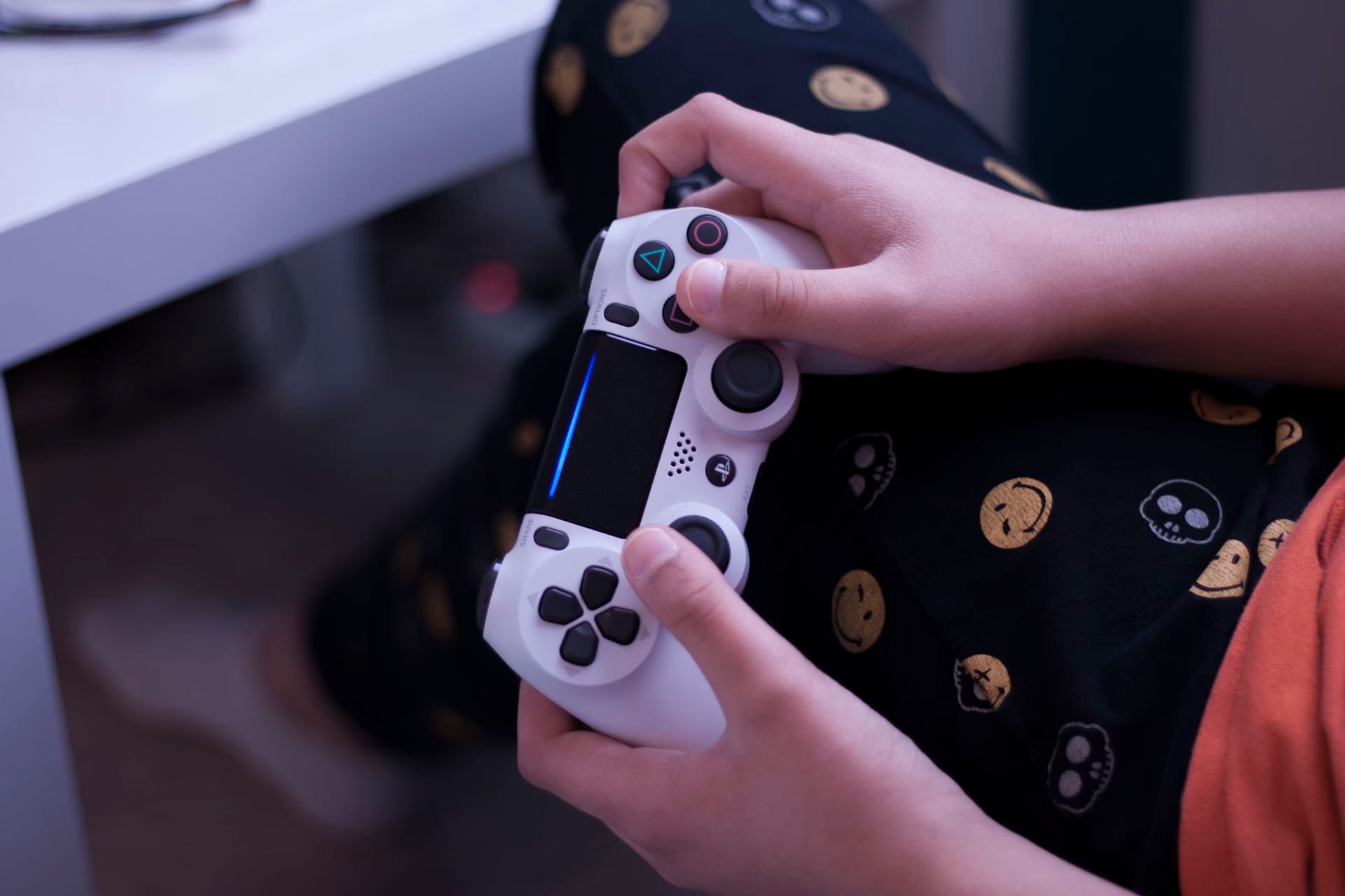Kinderhanden die een PlayStation-controller vasthouden.