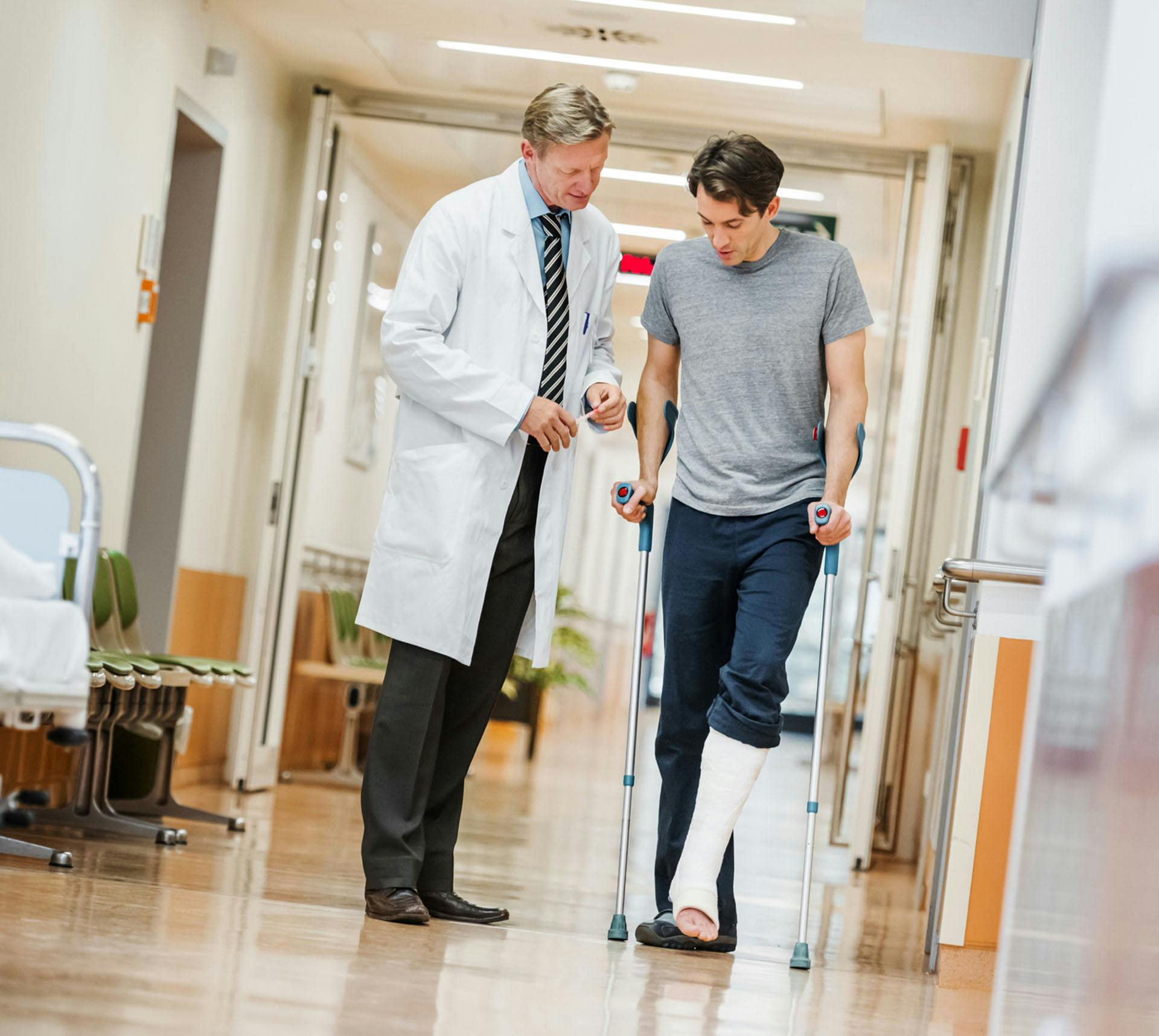 Doctor helping patient with injured leg