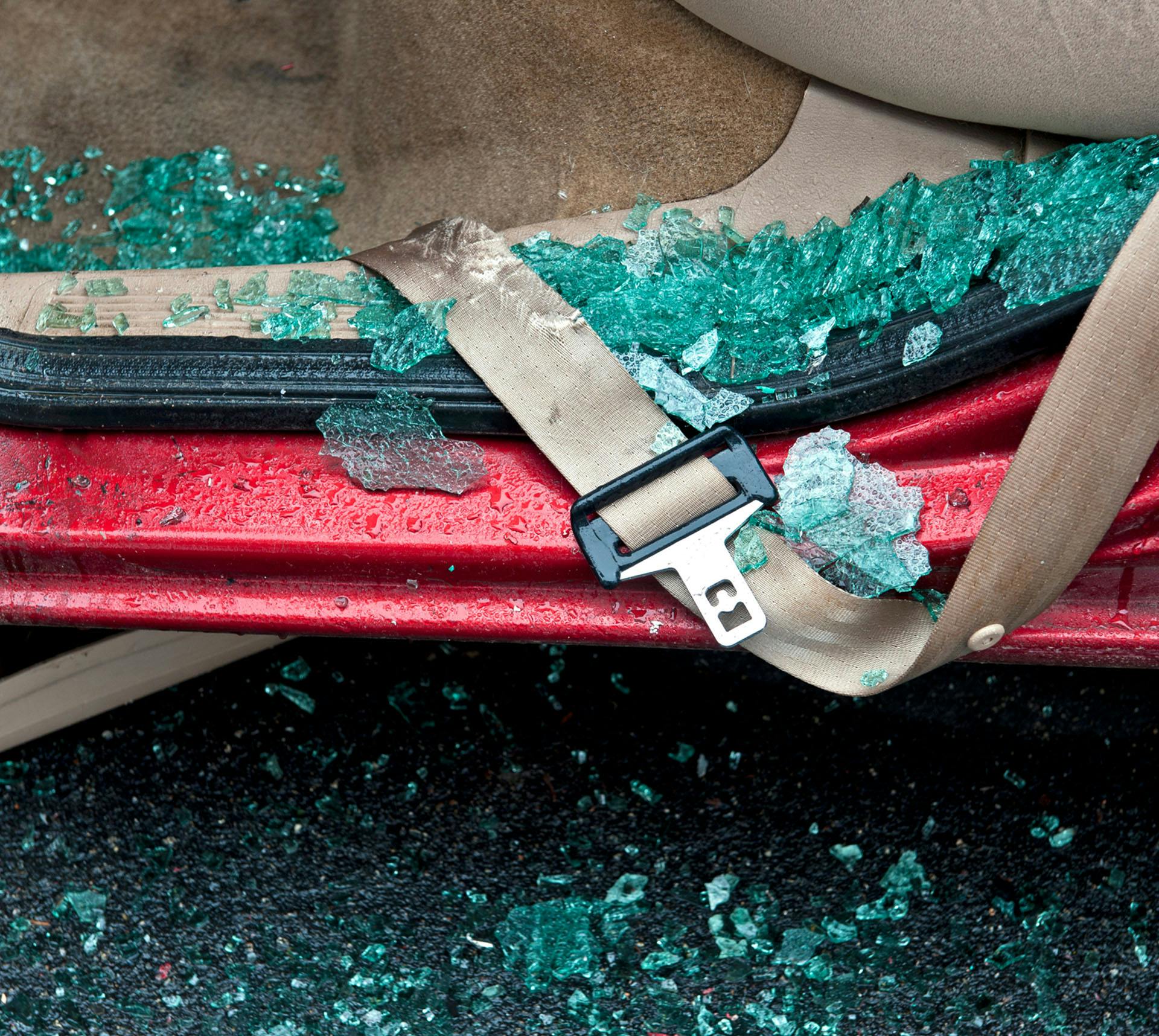Car with shattered window and broken seatbelt