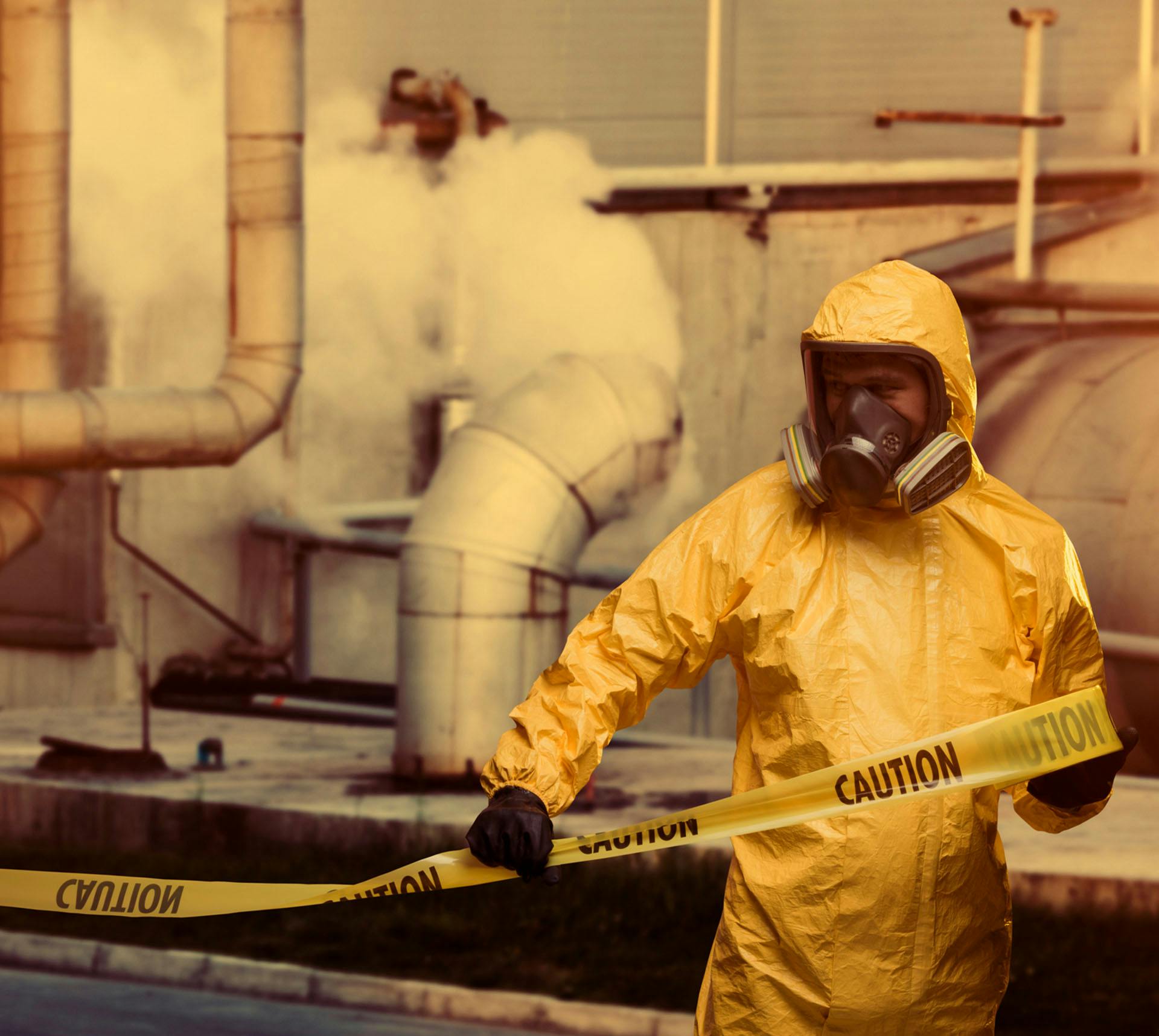 Man in hazmat suit putting up caution tape