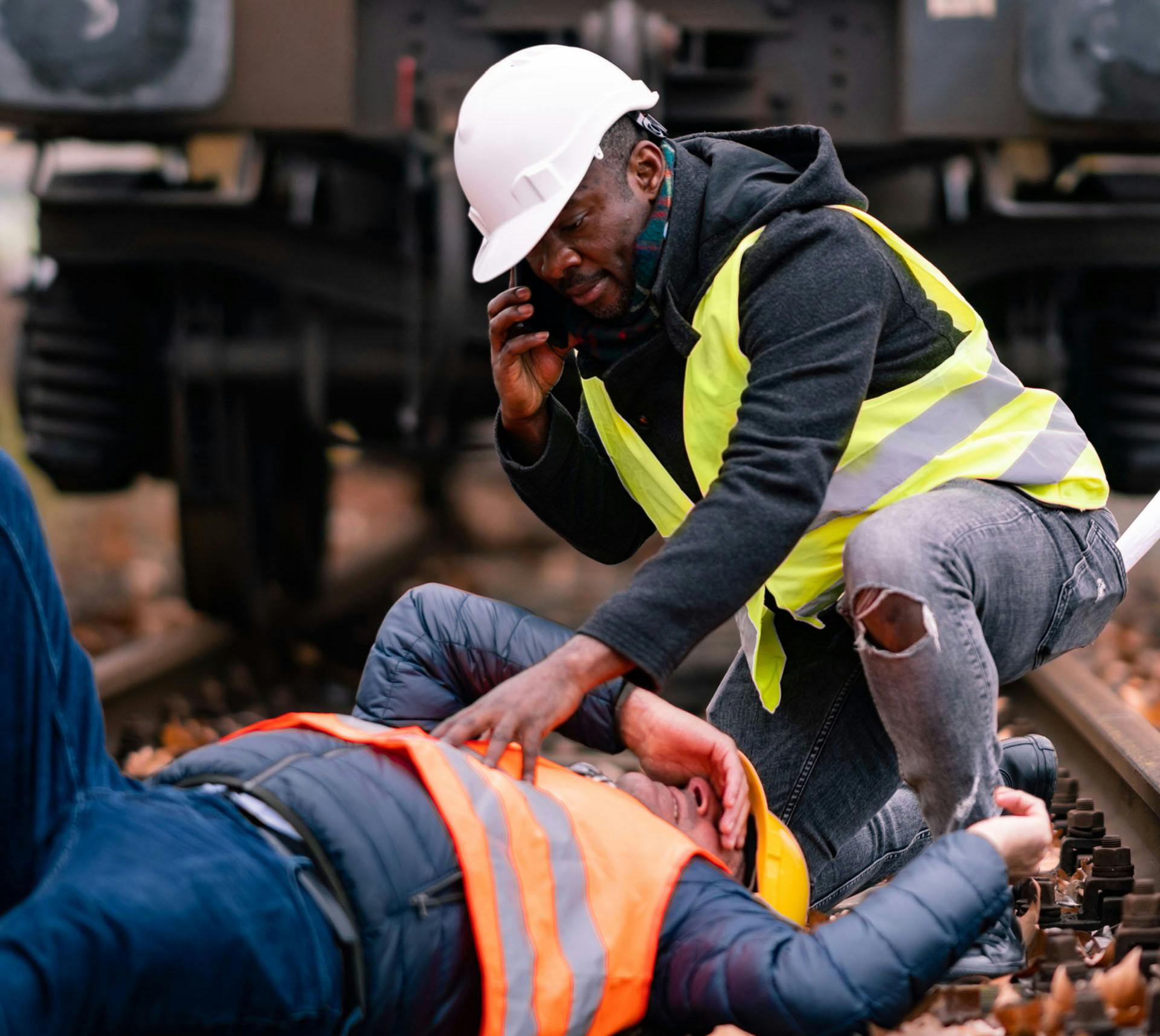 Injured railroad worker being helped by colleague