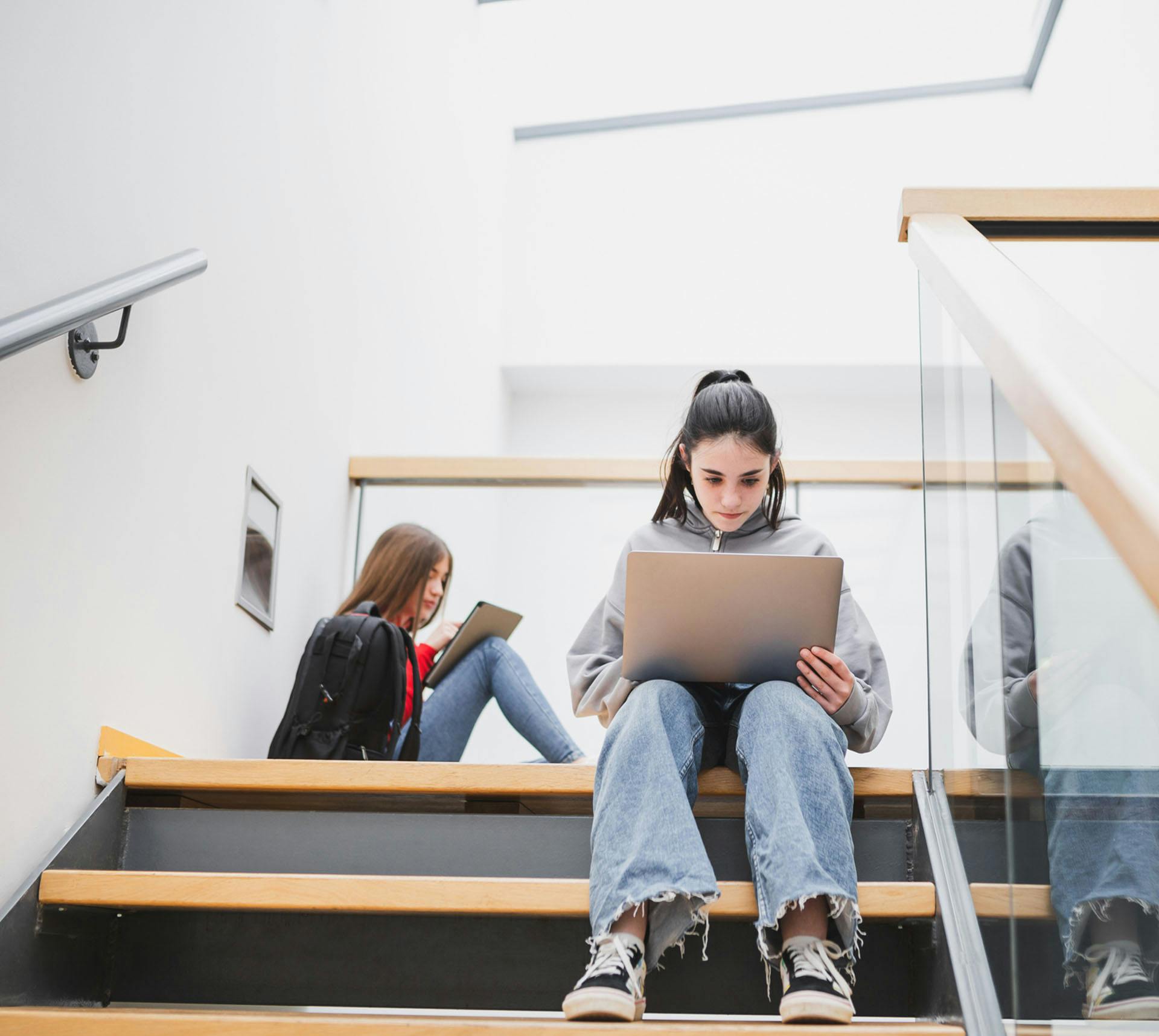 Student working on laptop on the stairs