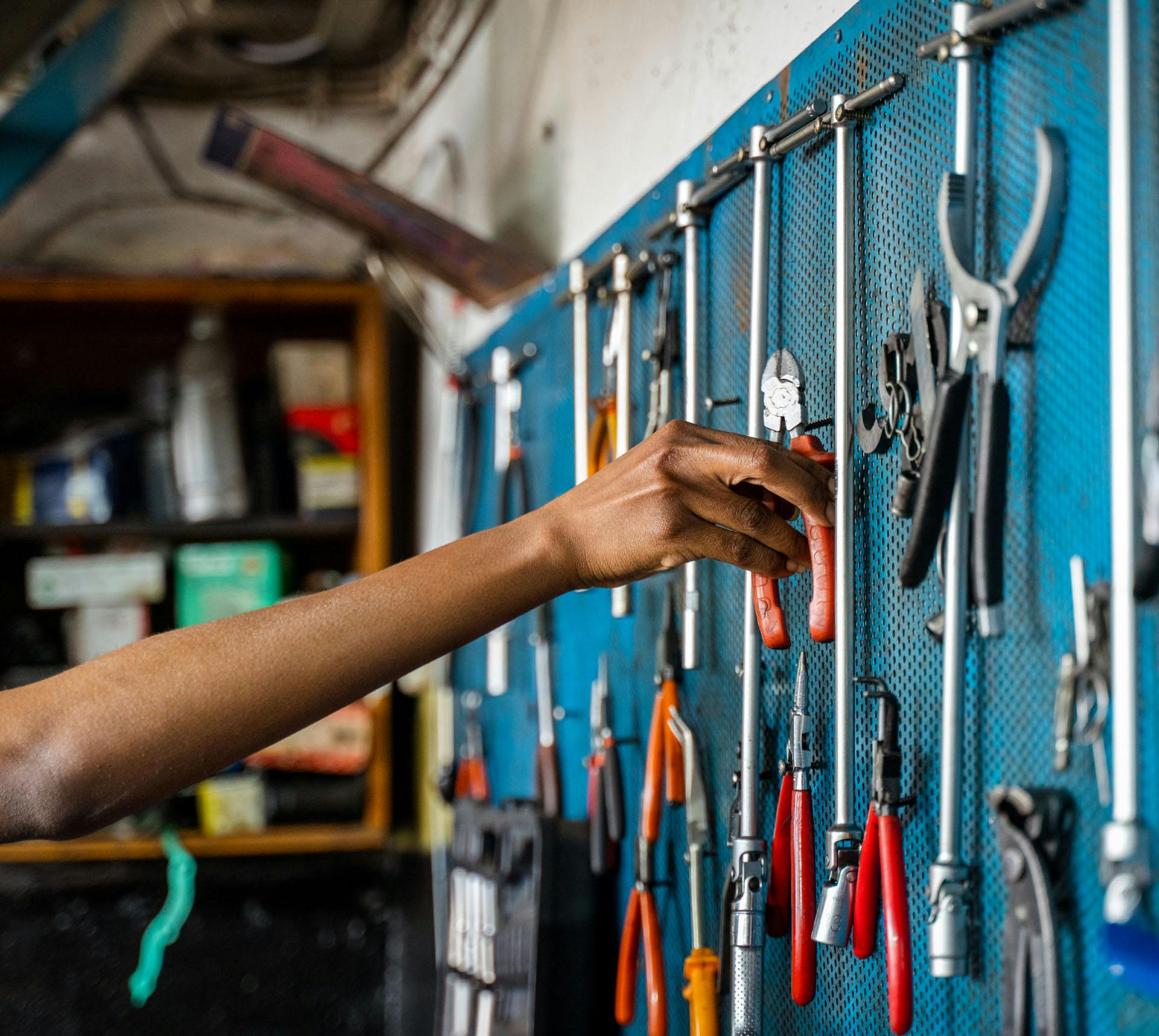 Person grabbing tool from tool display