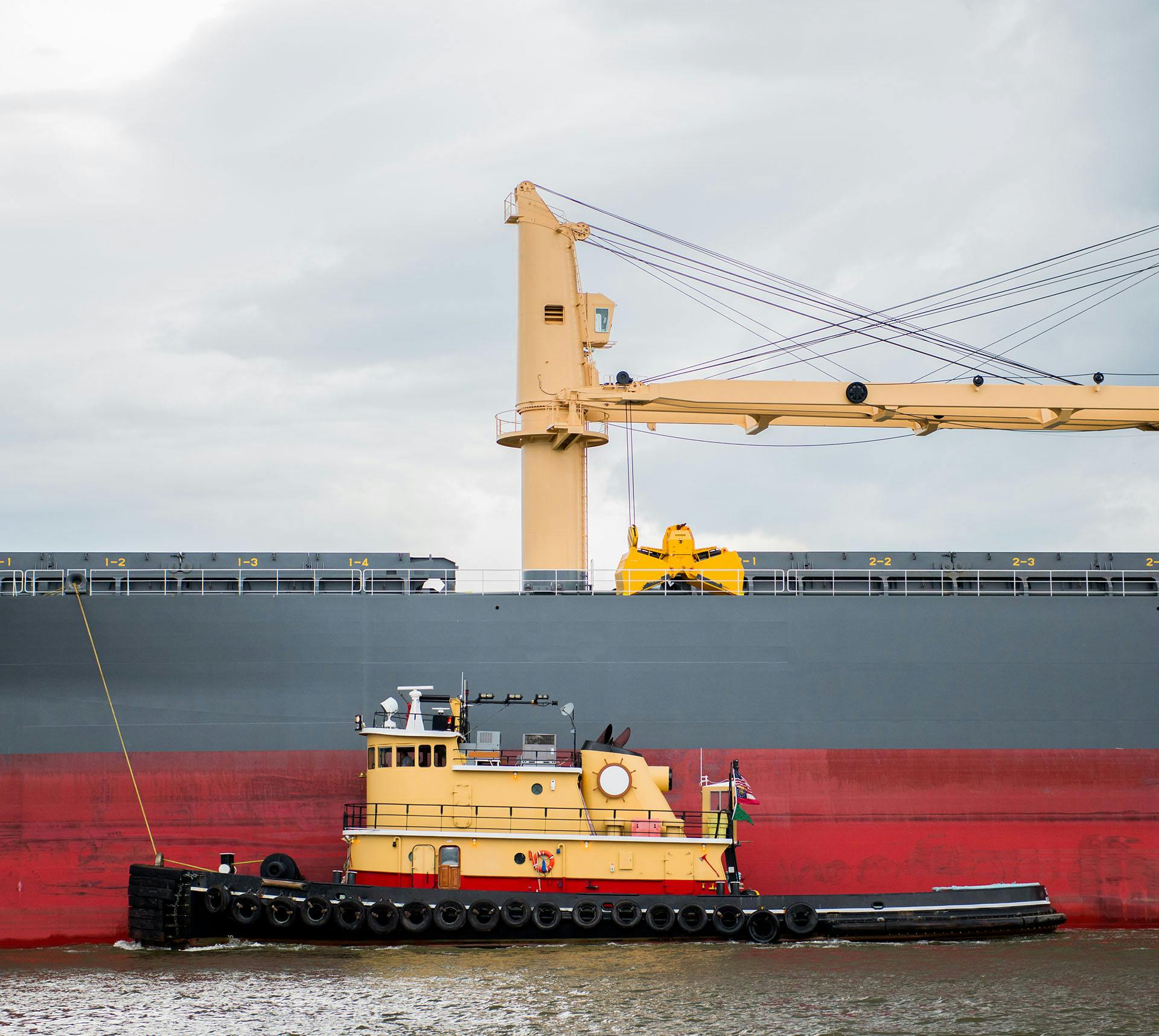 Large ship next to a tugboat