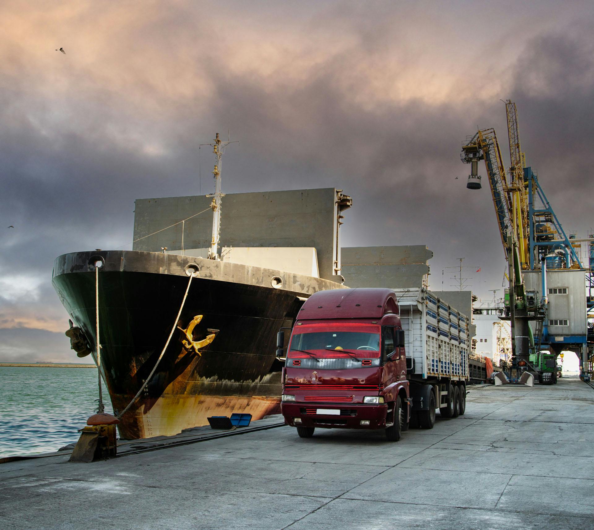 Boat docked next to large truck