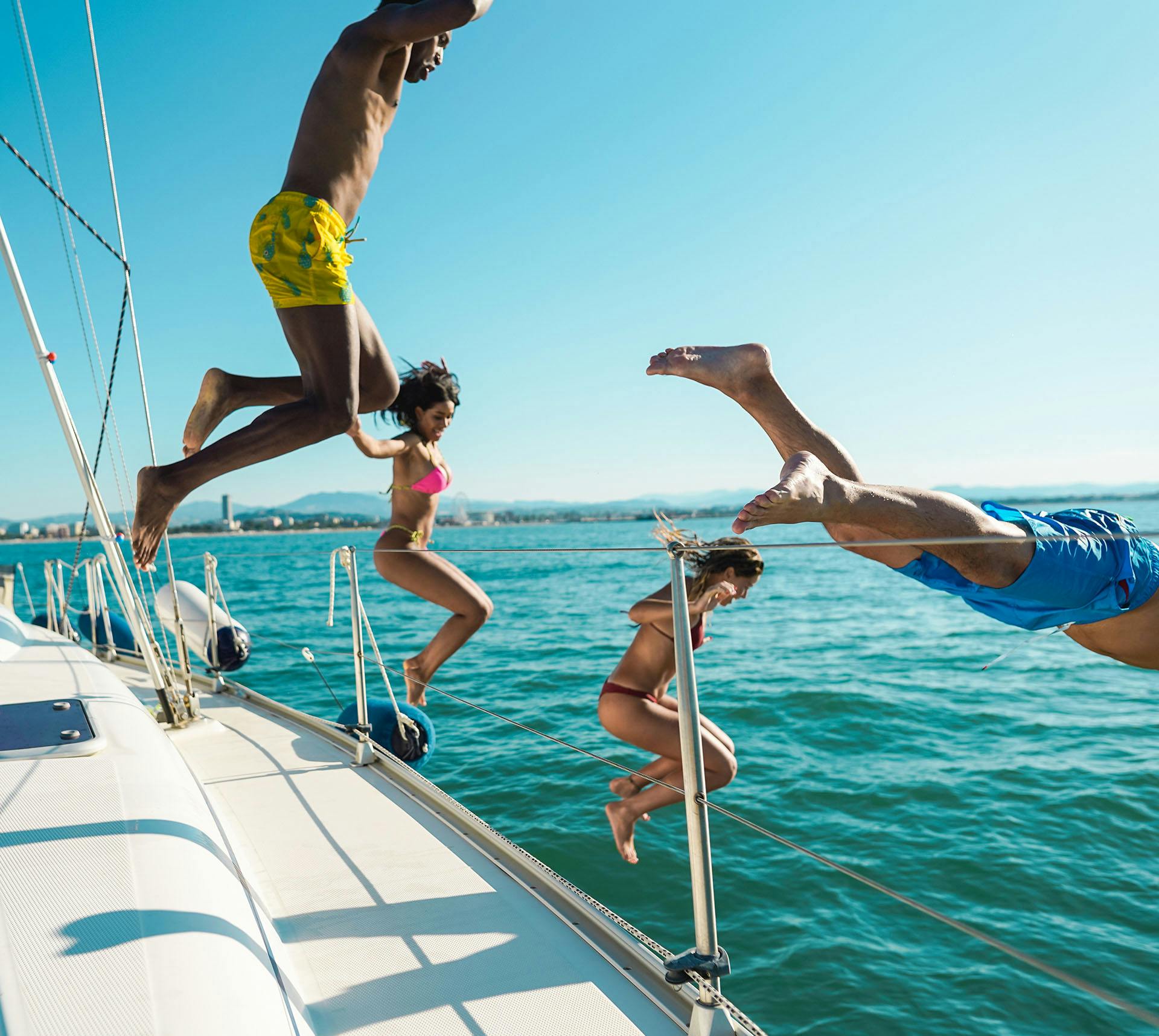 People happily jumping off a boat