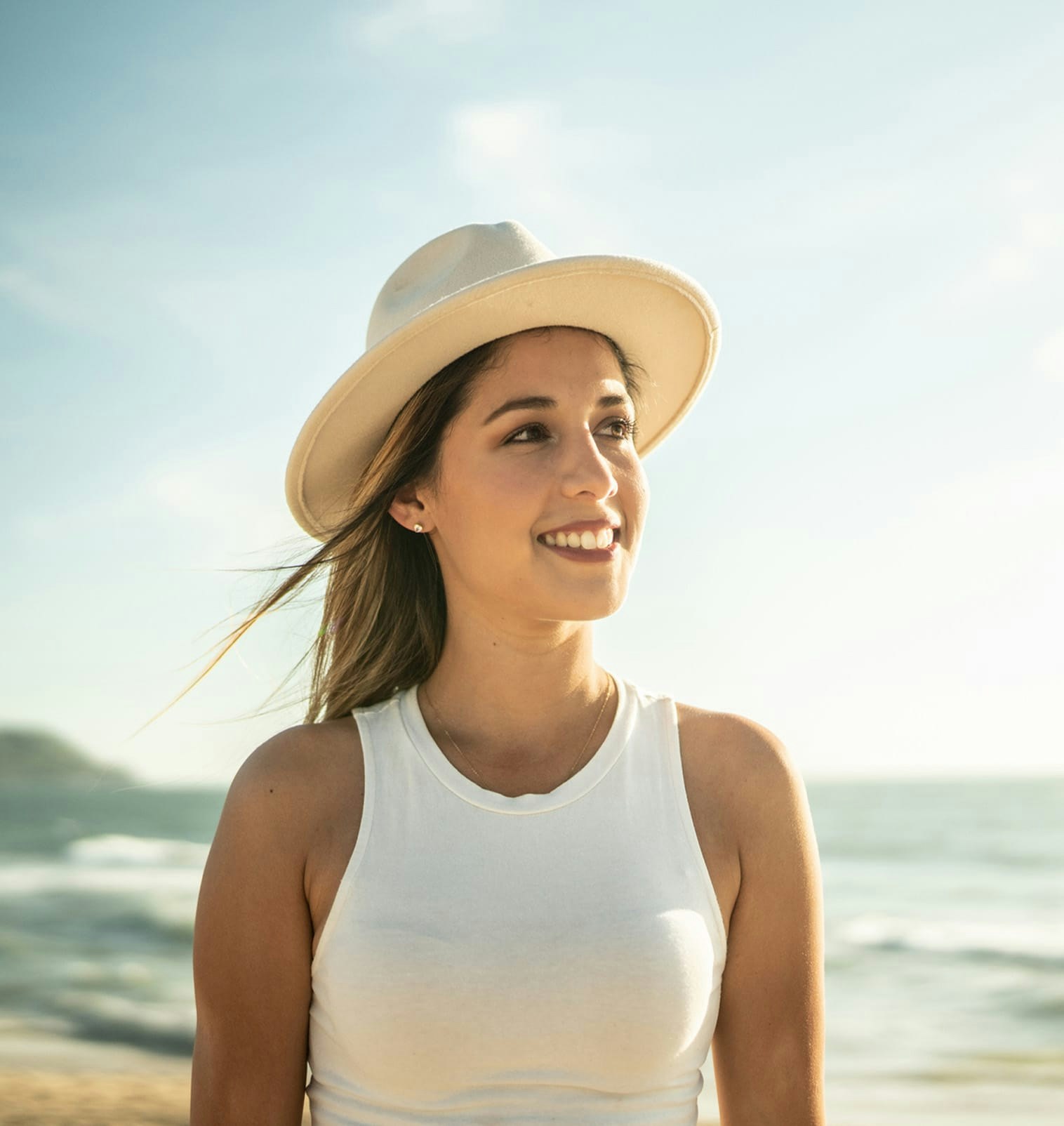 Woman wearing a sunhat walking on the beach