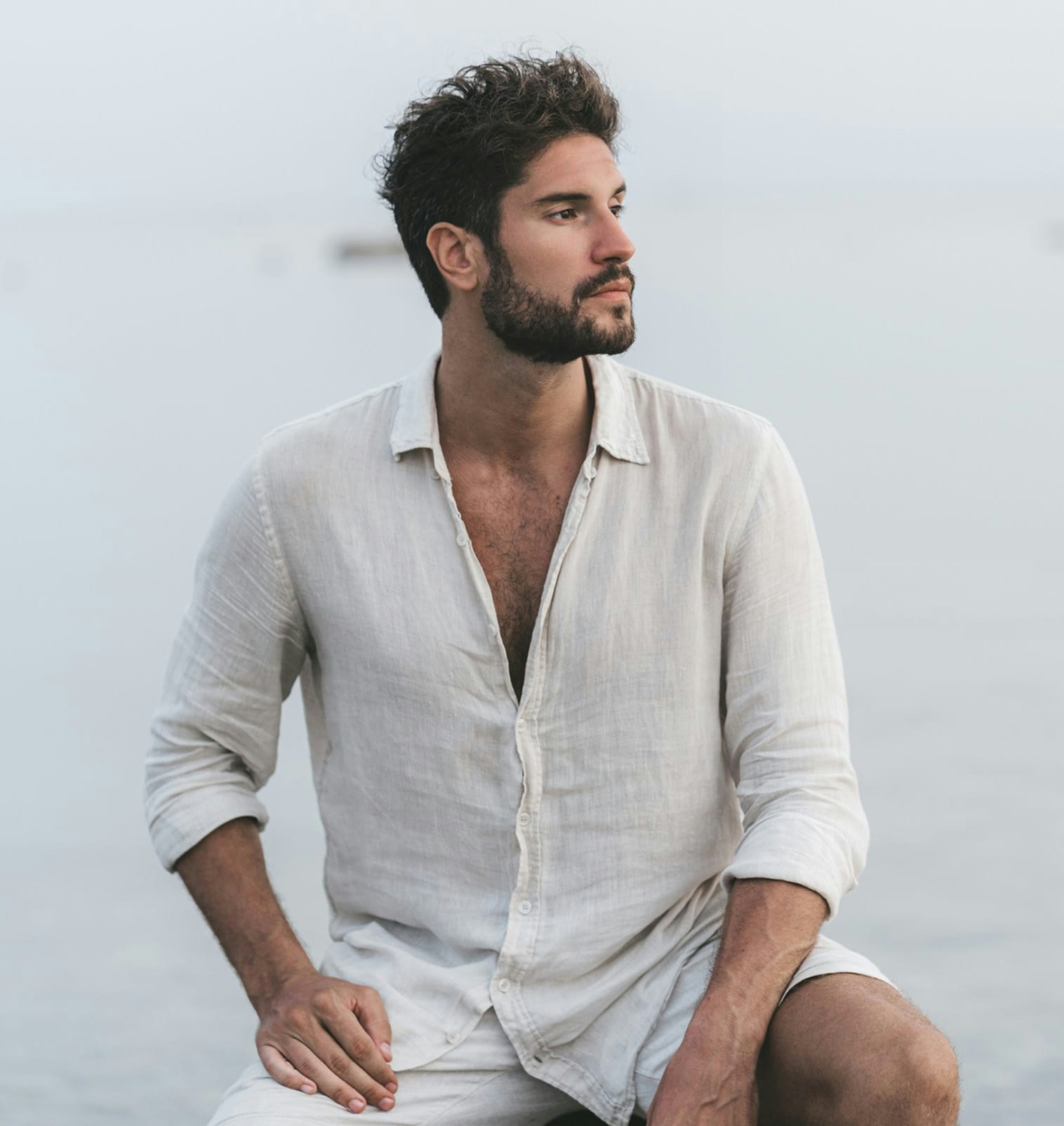 man in contemplation looking to the left wearing linen button-up