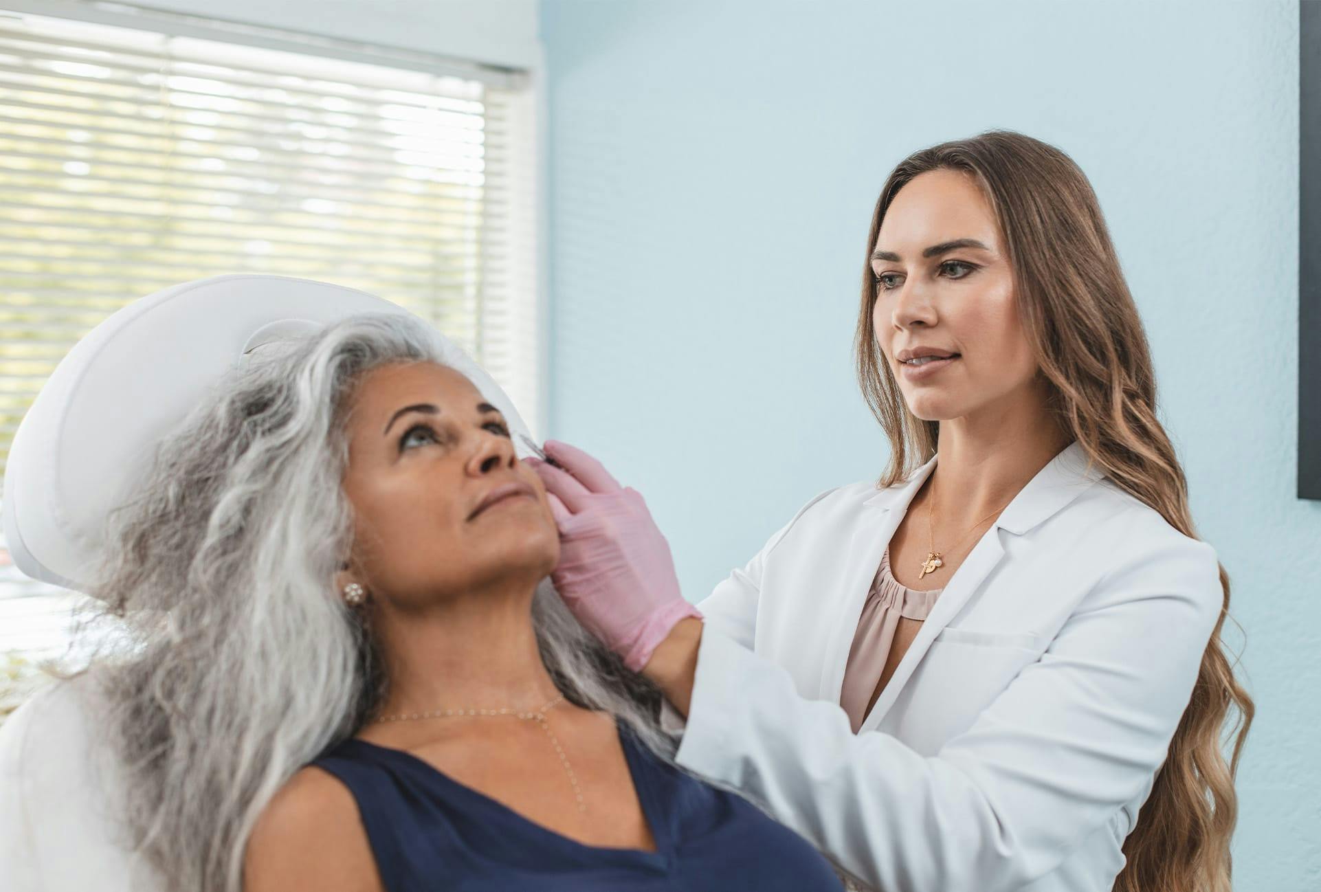 doctor administering BOTOX to woman patient in chair