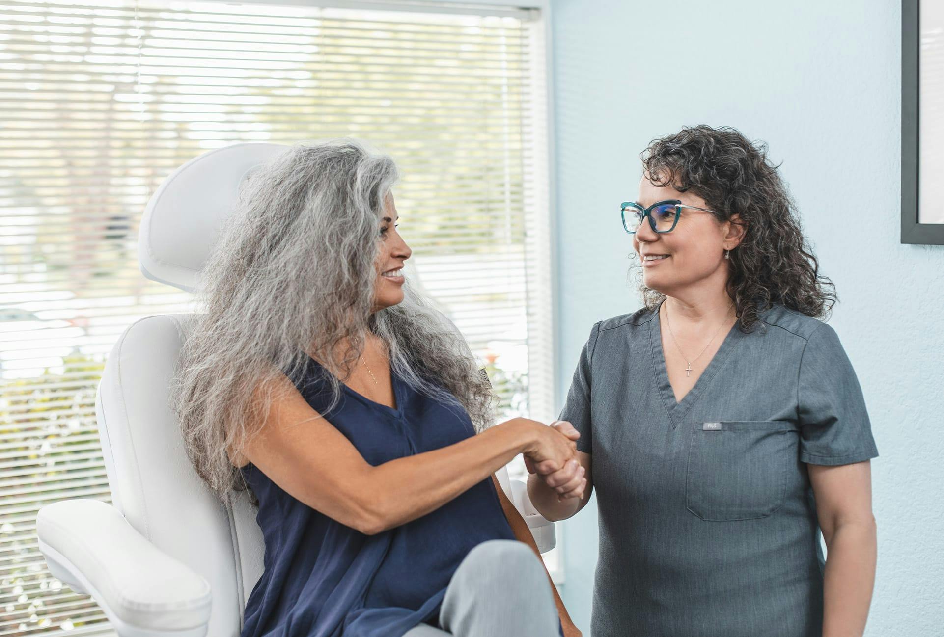 patient in chair shaking hands with doctor Dr Cernaianu