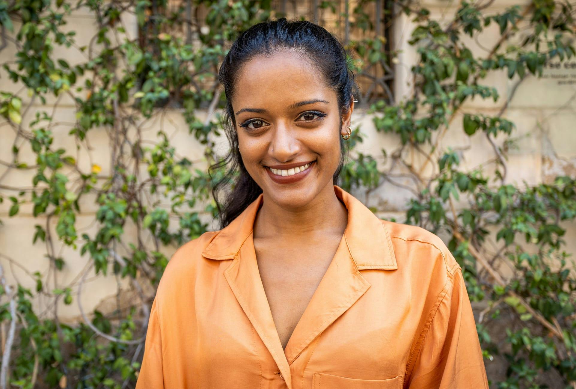 smiling woman wearing salmon colored blouse