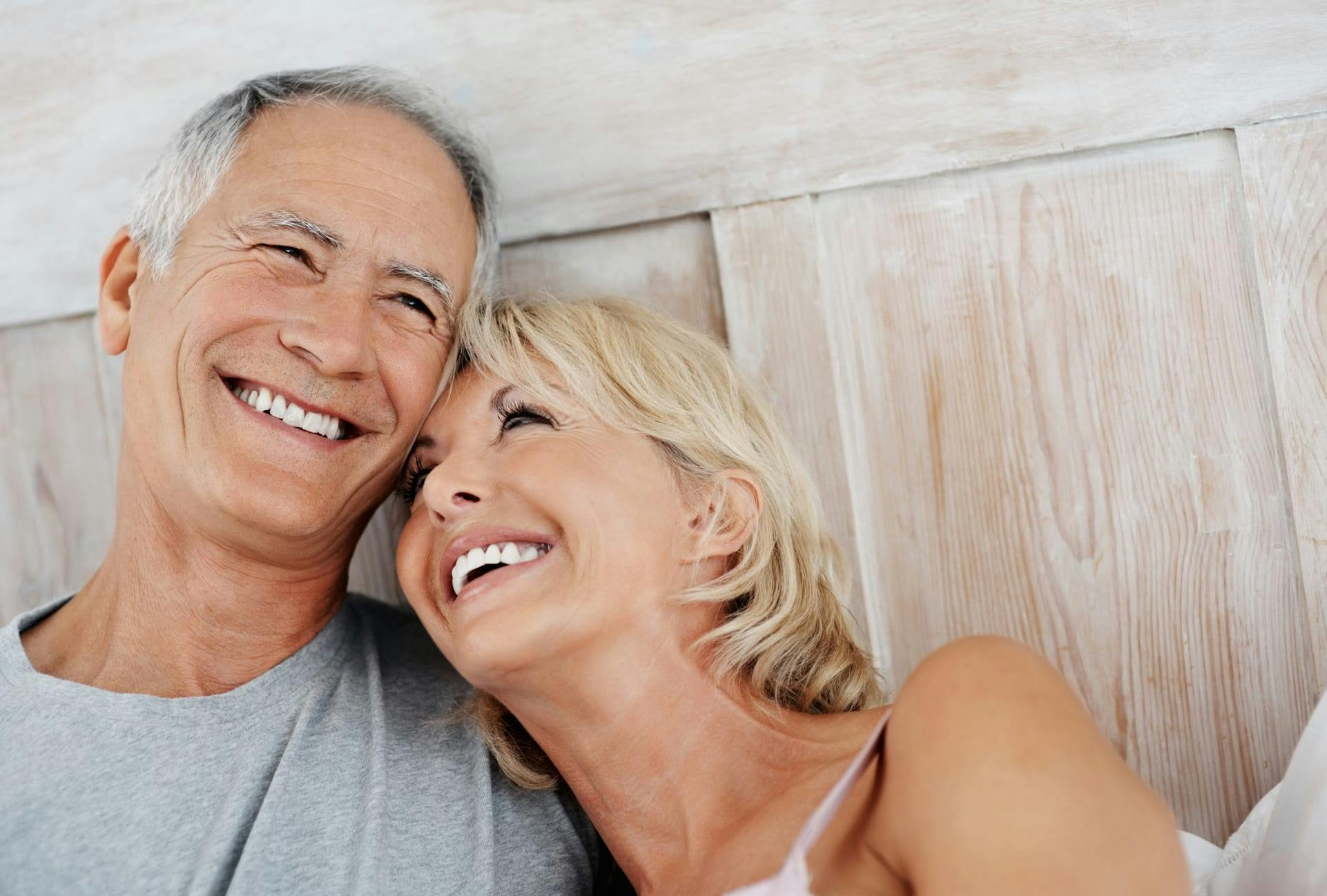 smiling woman with head on shoulder looking up at smiling man