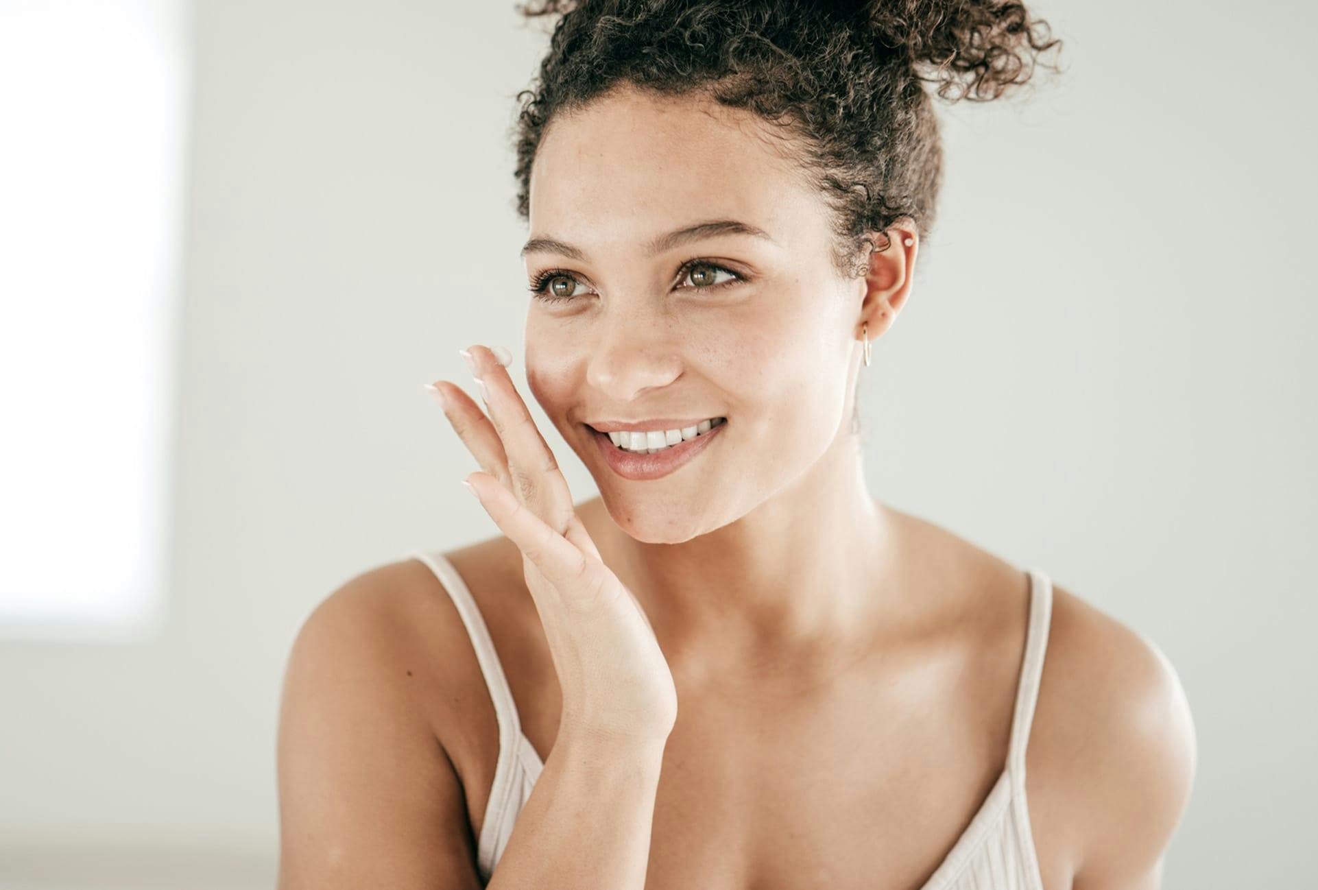 Woman happily doing her skincare