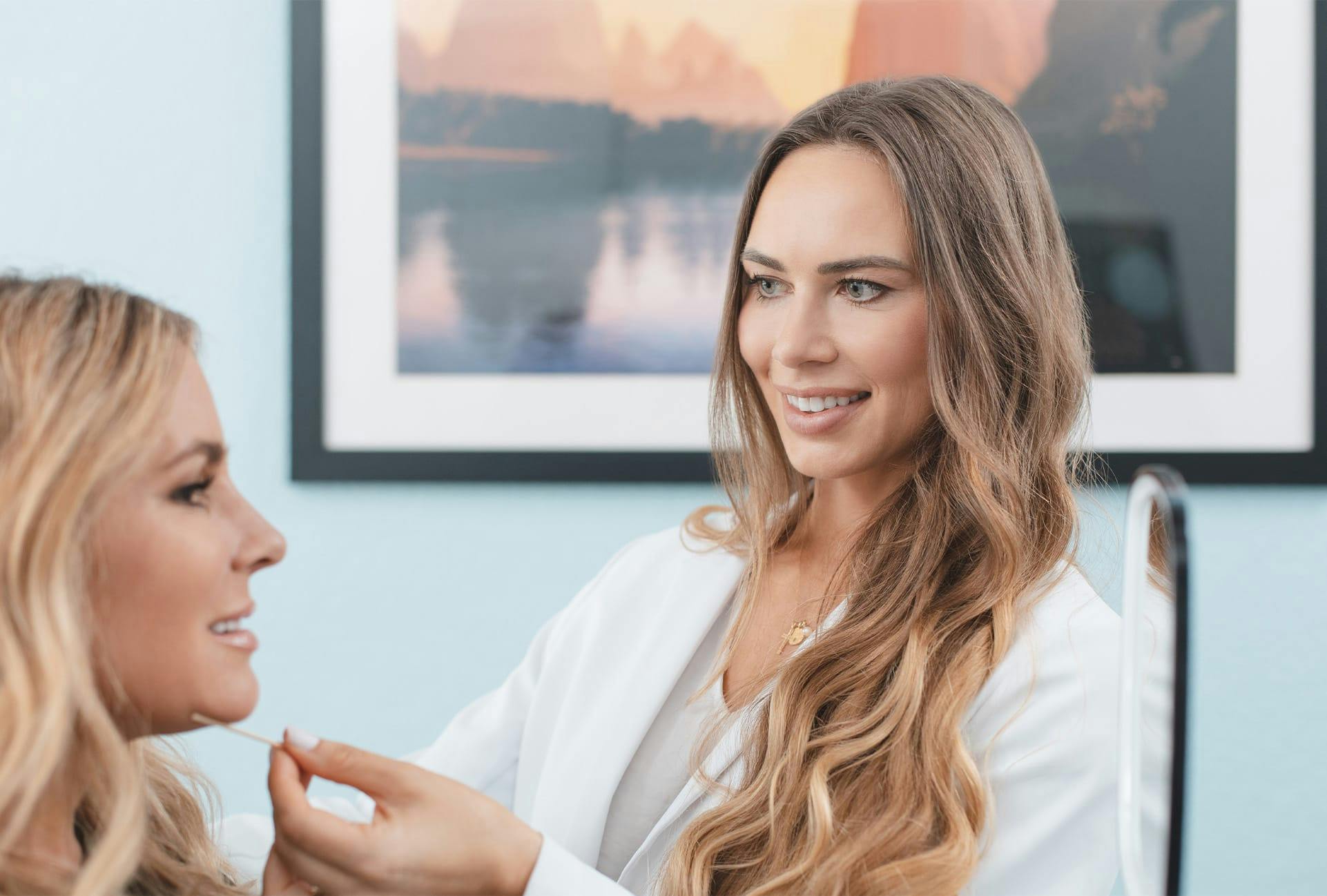 smiling doctor holding swab to smiling patient's face