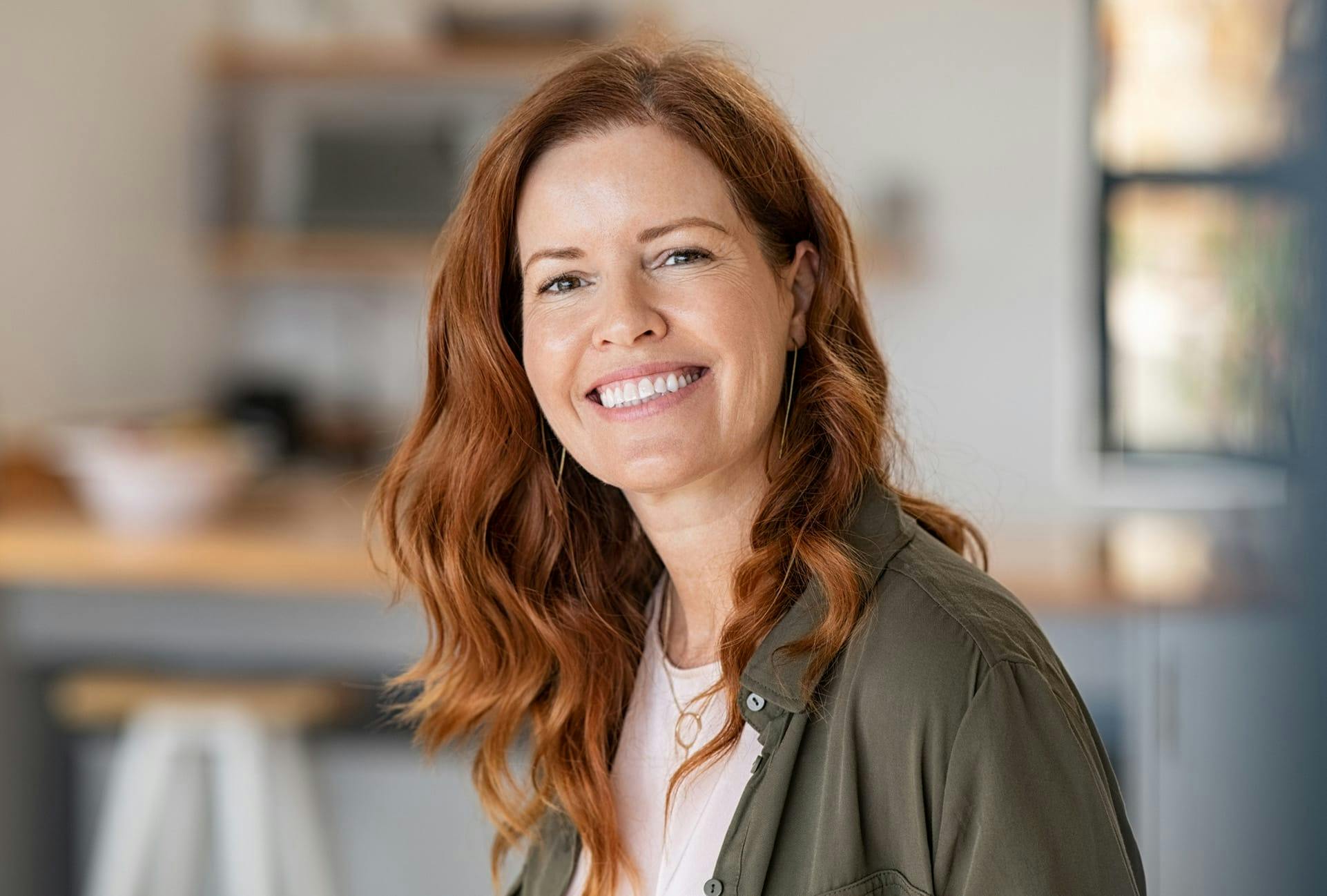 smiling woman wearing olive green button-up