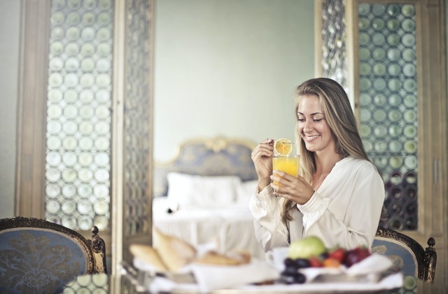 woman smiling and drinking orange juice