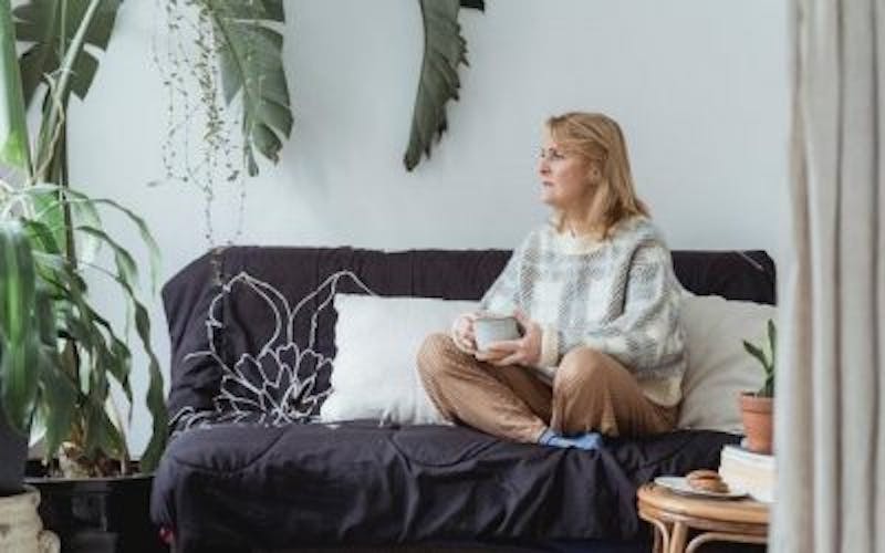 woman sitting on a couch with a cup of coffee