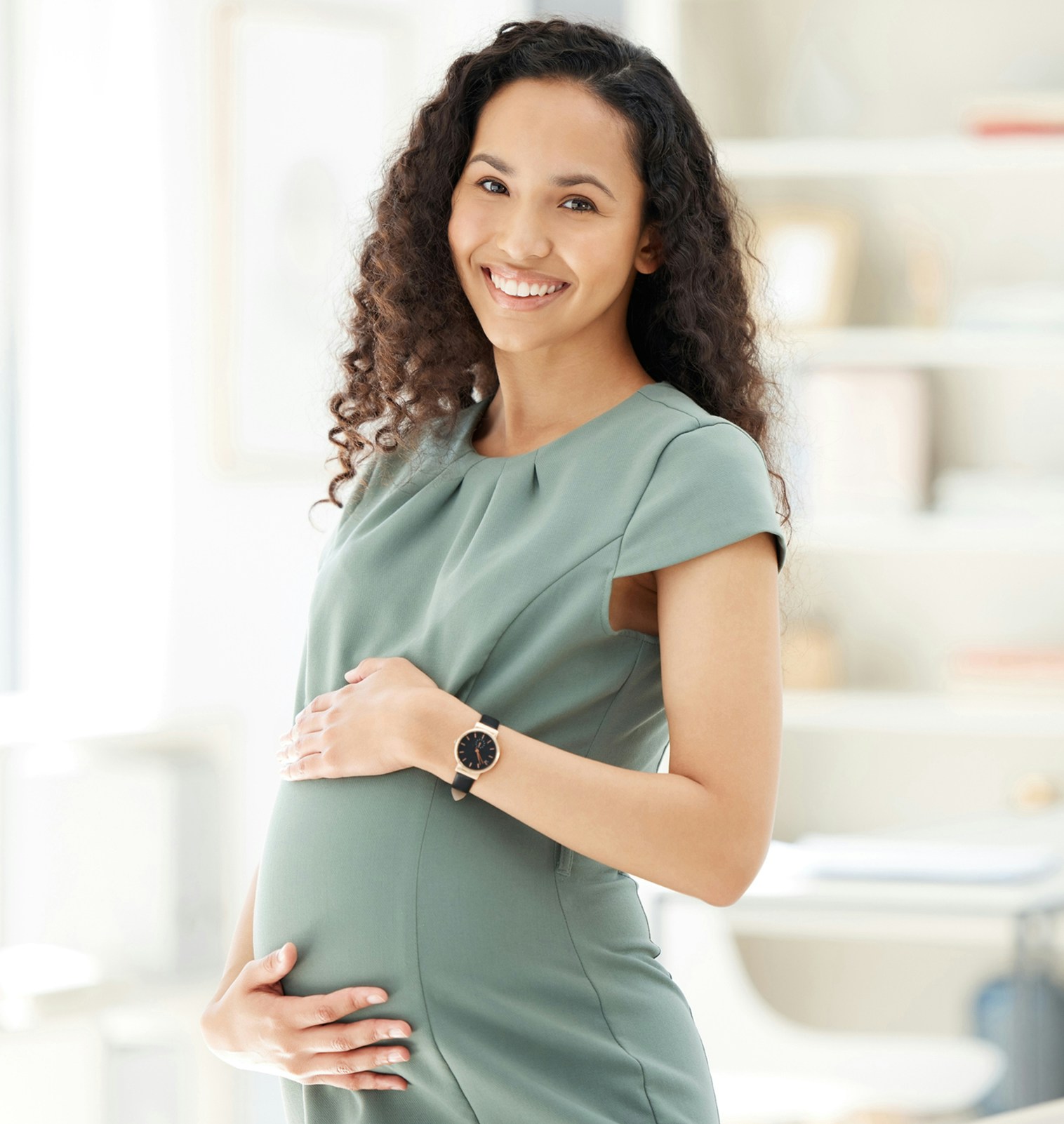 Pregnant woman holding her stomach and smiling
