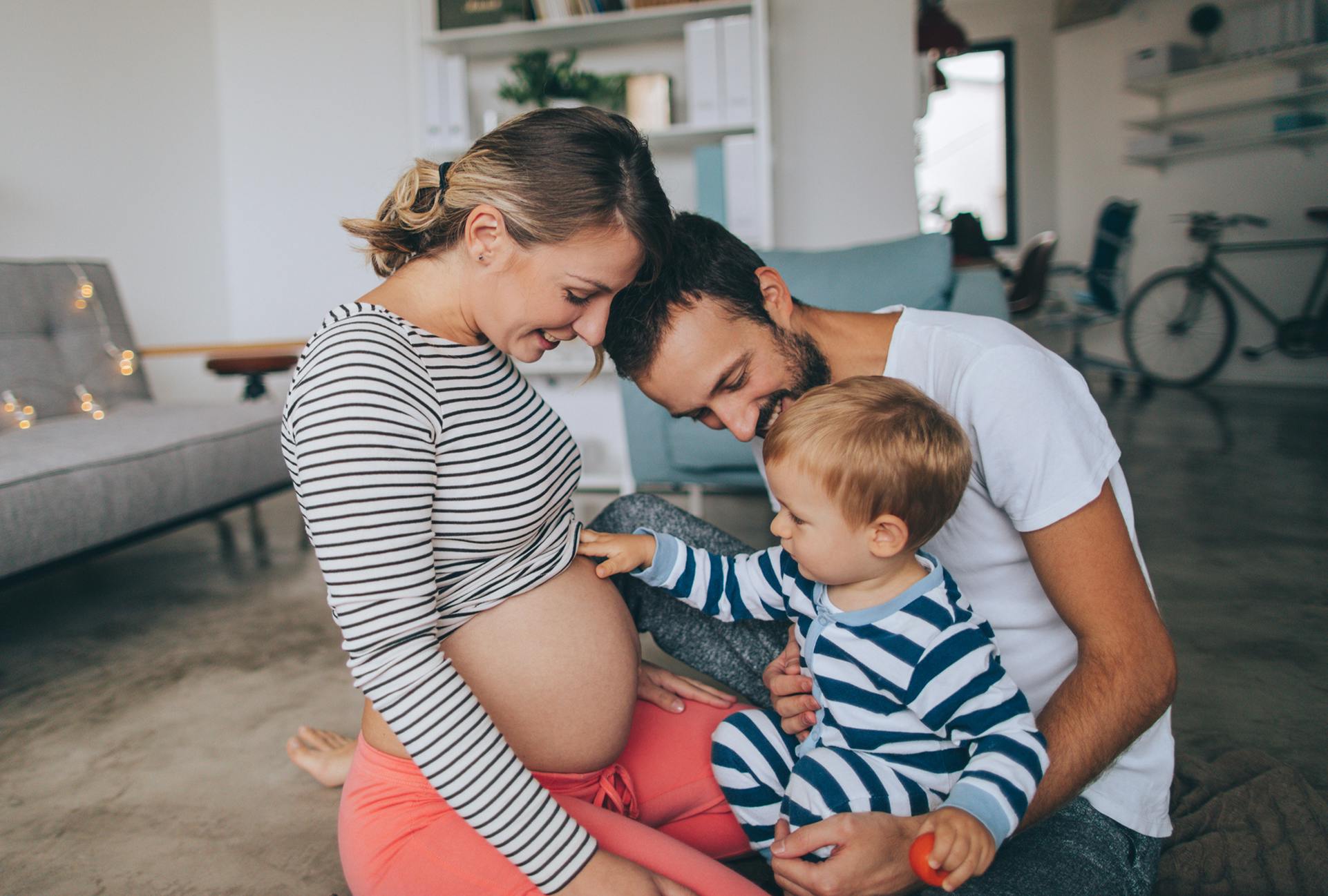 Pregnant woman with her husband and baby
