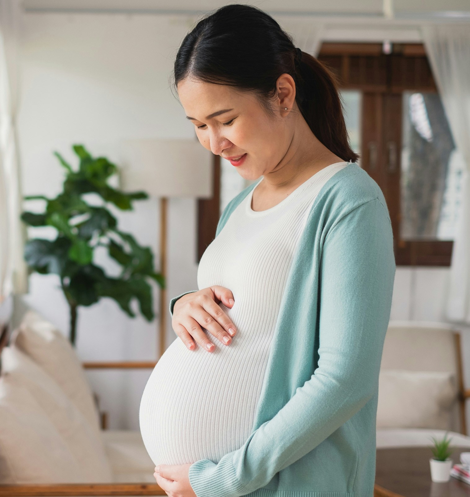 Pregnant woman happily holding her stomach