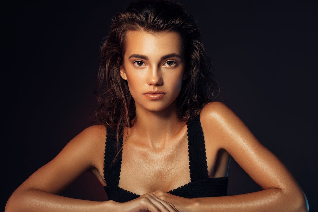 Woman with perfect skin stairs at the camer with glowing skin