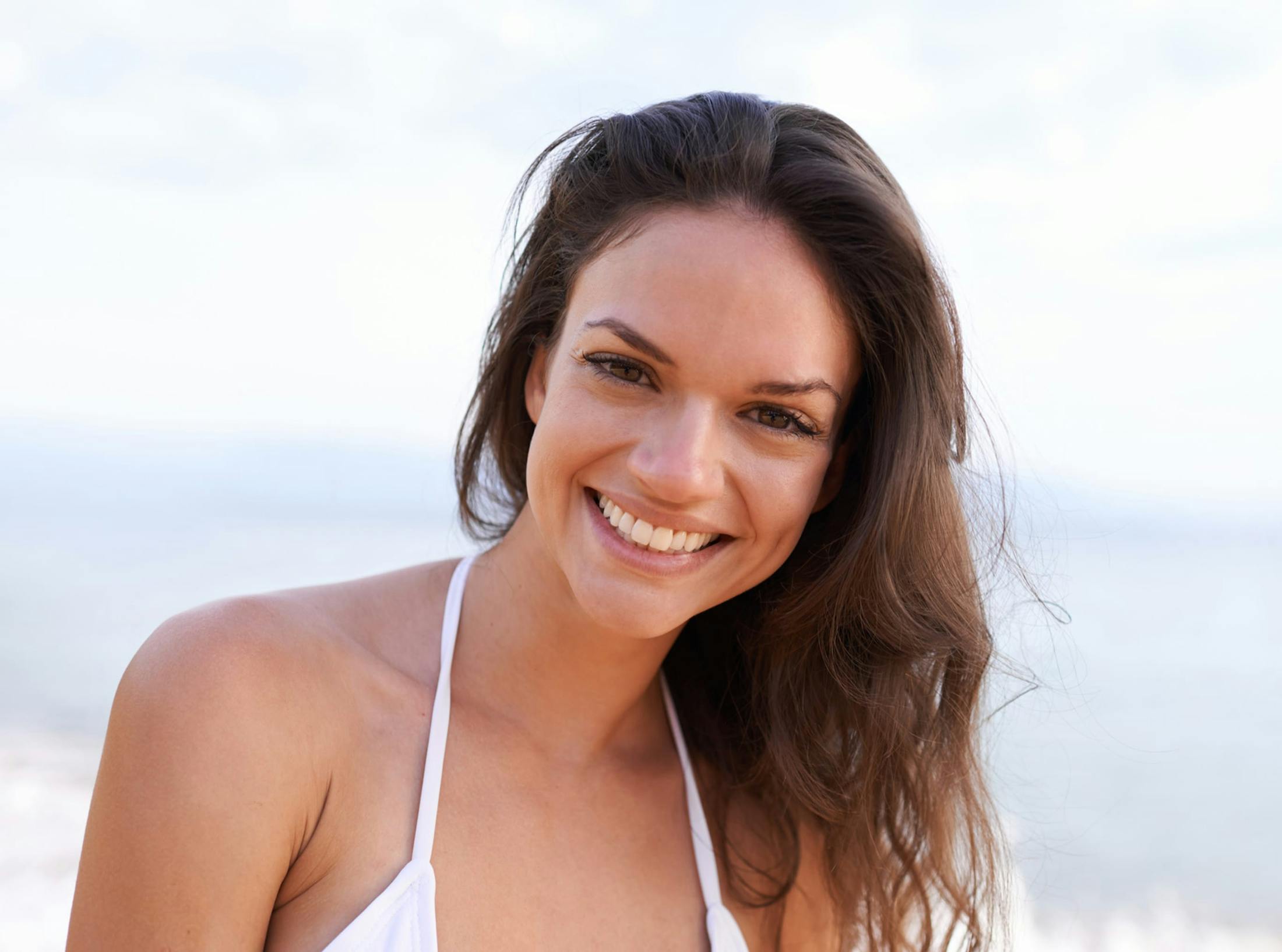 smiling woman in white halter top