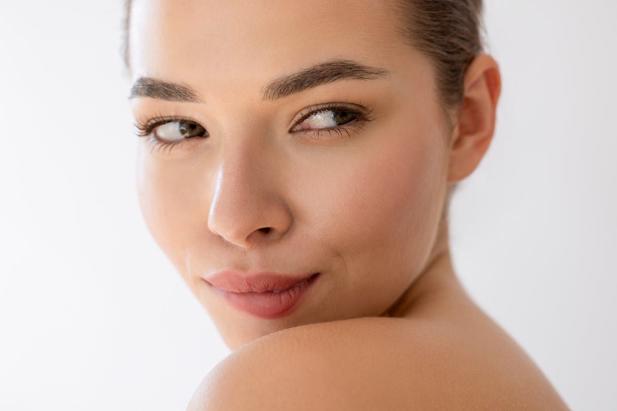 Beautiful Face of a woman looking over her shoulders showing off plump lips hydrated skin and a youthful appearance