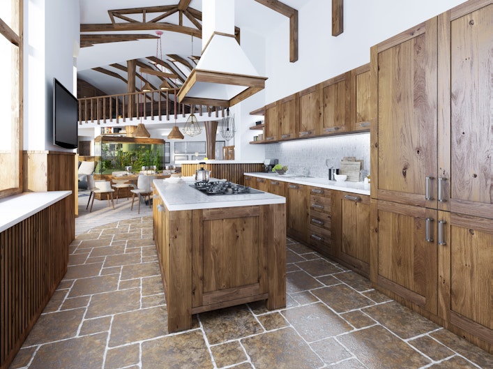 The large kitchen in the loft style with island. Wooden furniture with white worktops and mosaic with integrated appliances.