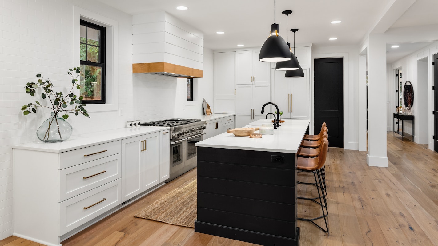 Beautiful white kitchen with dark accents in new modern farmhouse style luxury home