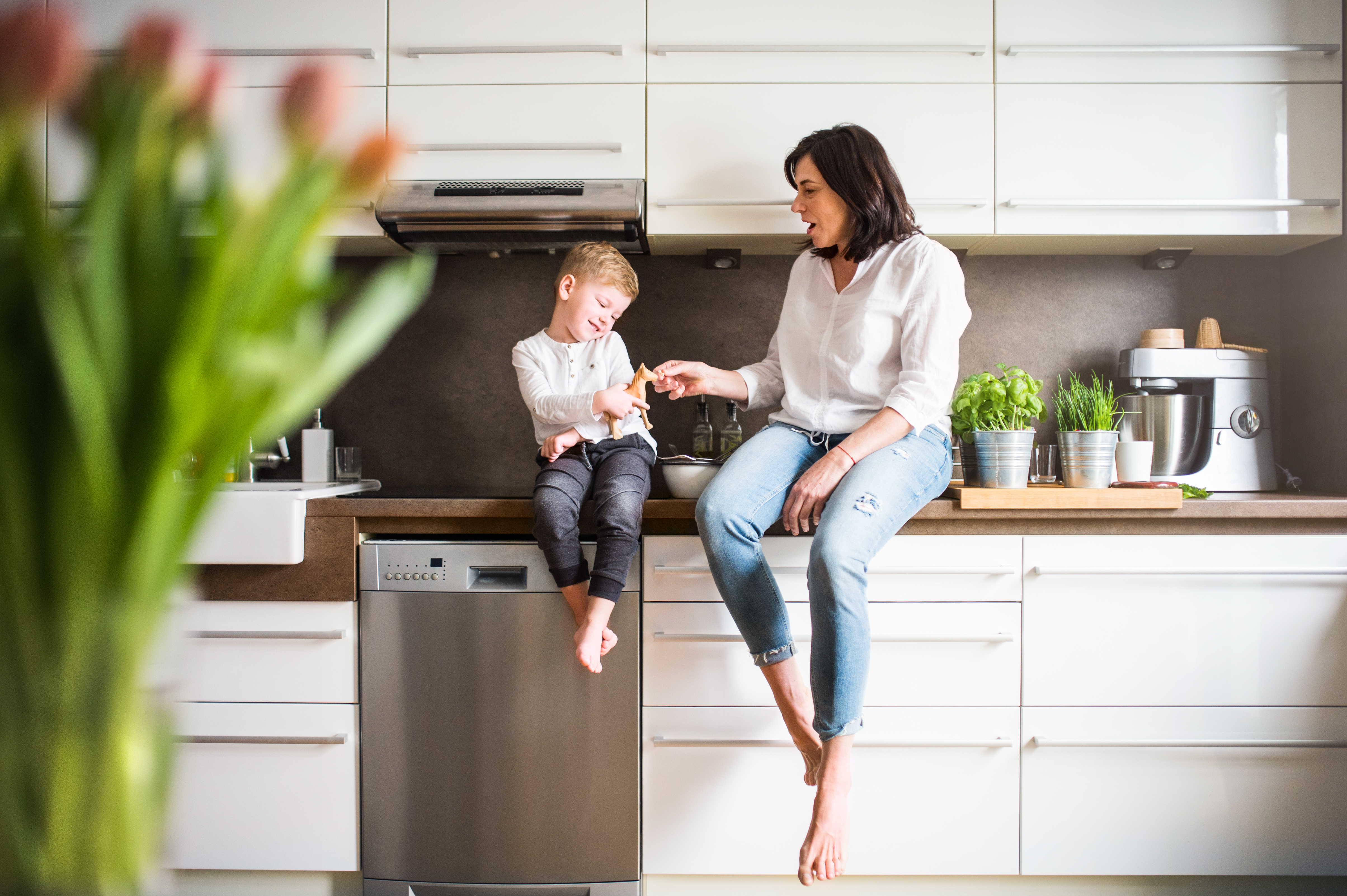 Mon and son chatting while sitting on the kitchen counter
