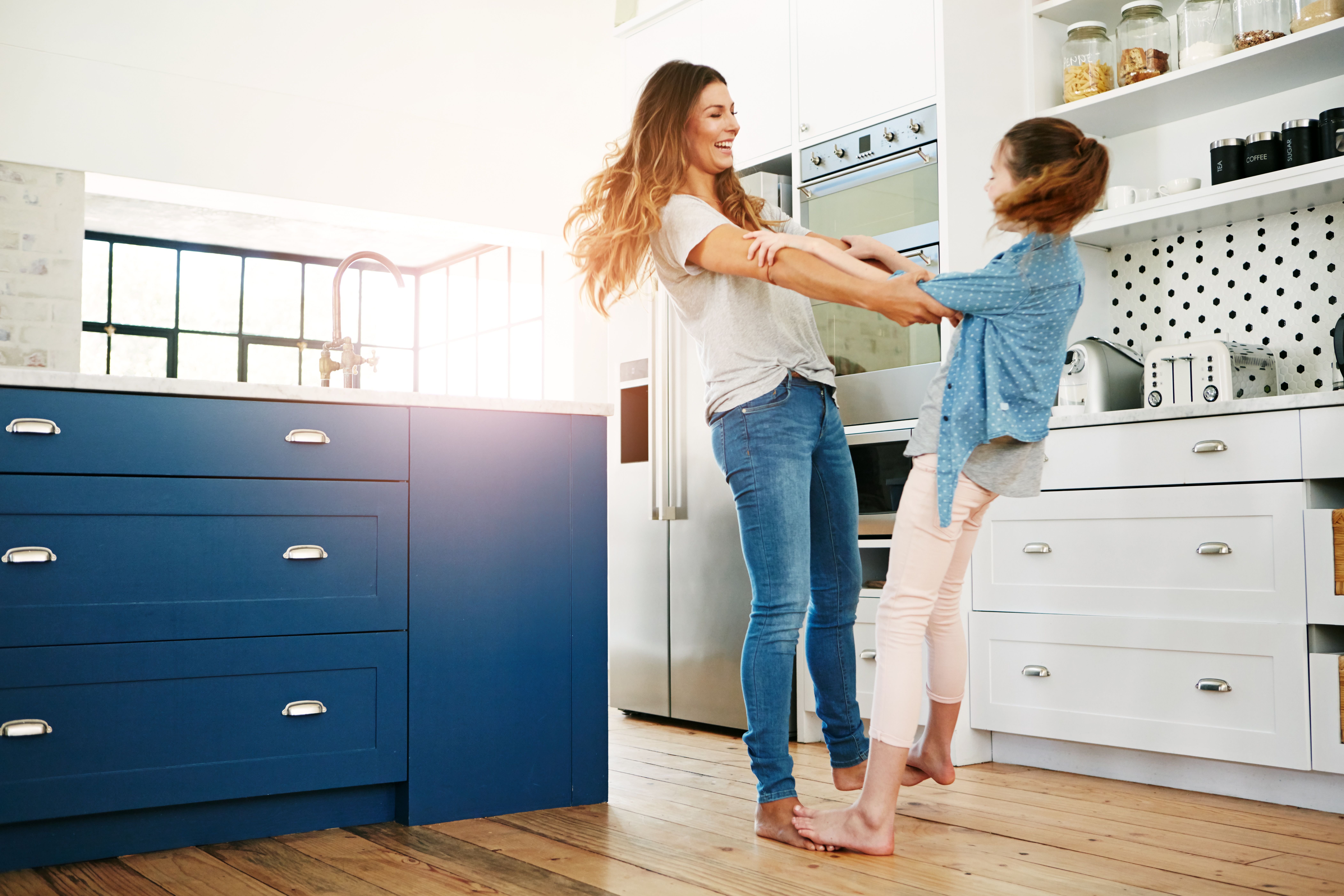 Mommy and daughter playing and having fun in the kitchen