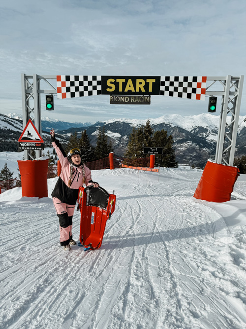 Personne prête à descendre en luge, installée sous l’arche de départ à Courchevel Moriond.