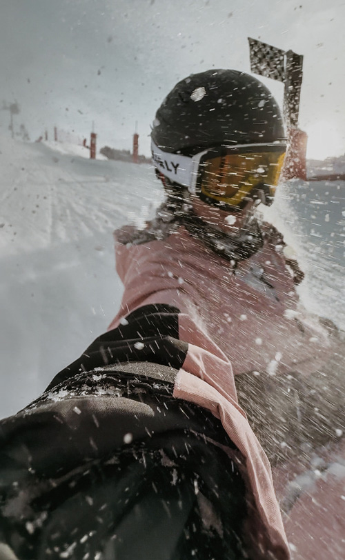 Personne en luge prenant un selfie pendant la descente, flou de mouvement visible.