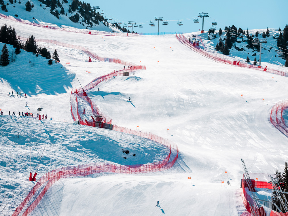 Ski competition on the Eclipse slope in Courchevel, with a skier in full descent and spectators in the background.